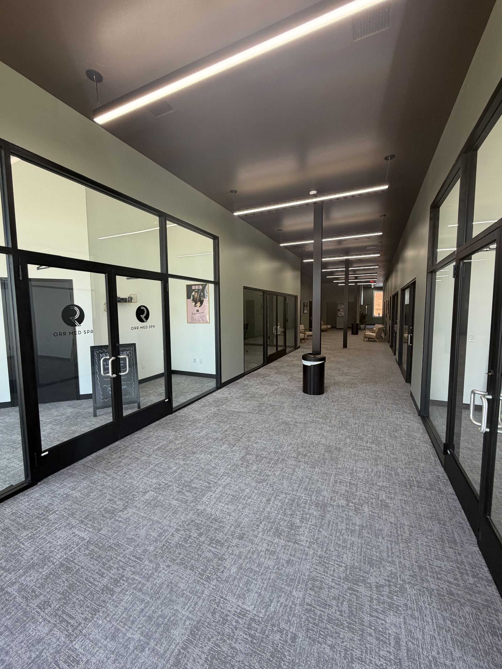 Hallway of glass-front private offices inside Avenue 118